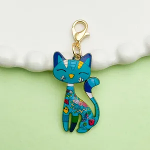 Detailed view of a blue enamel cartoon cat pendant with floral patterns and a gold clasp