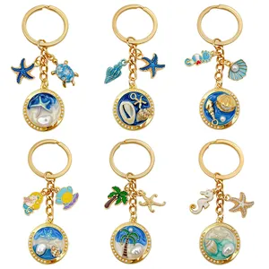 Detail view of ocean-themed keychains with shells, starfish, and gold metal charms.