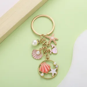 Close-up detail of ocean-themed keychain with shell, starfish charms and pearls