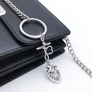 Close-up of a silver medical keychain with anatomical heart and pulse wave charm