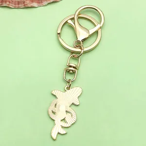 Close-up view of a stylish golden metal whale dolphin keychain pendant for bag accessory