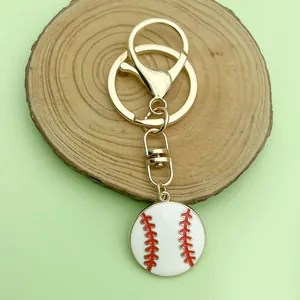 Nahaufnahme eines weißen Baseball-Anhängers mit roten Nähten an einem goldenen Schlüsselring