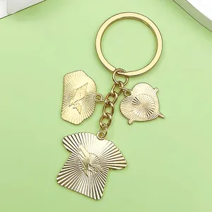 Close-up of gold nurse themed charms including a scrub, cap, and heart on a keychain