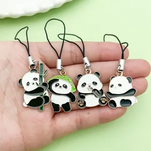 Detailed macro view of four cute panda enamel charms held in a hand for scale display.
