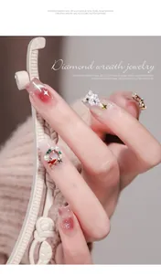 Detailed view of Christmas wreath and star nail art charms on manicured fingernails