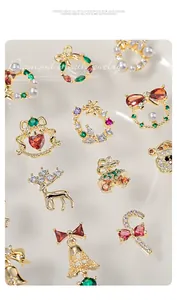Detailed macro view of luxurious gold Christmas nail charms with colorful zircons