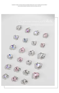Detailed macro view of mini nail art rhinestones with heart, butterfly shapes and pearls