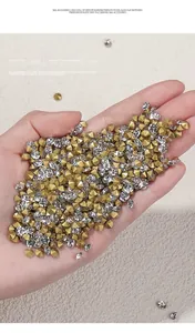 Gros plan de strass pour nail art dorés et transparents à fond pointu