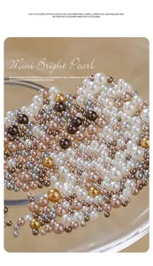 Close-up macro view of mixed size Maillard style high-gloss decorative nail pearls.