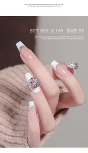 Primer plano de un dije de uñas de cristal rosa con forma de corazón y aleación.