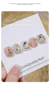 Detailed macro view of Maillard style nail art pearls and charms on acrylic nails