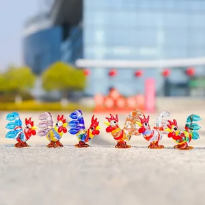 Macro view of six colorful miniature glass rooster figurines on an outdoor stone ledge.
