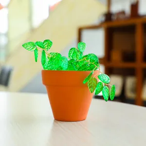 Détail d'une plante attrape-soleil DIY avec feuilles en verre et pot en terre