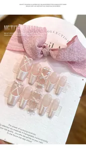 Detail showing press-on nails with French ribbon patterns and 3D pearl bows