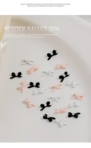 Detail view of ballet bow nail charms with pearls in black, white, and pink colors