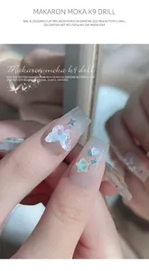 Close-up van mocha K9 kristallen vlinder en ster nagelkunst bedeltjes op nagels