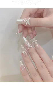 Detailed macro view of French ballet slipper style press-on nails with ribbon bows and pearls