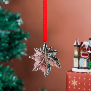 Close-up of crystal maple leaf ornament with red ribbon for Christmas tree decor