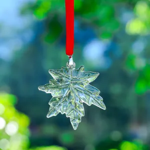 Beautiful crystal clear maple leaf sun catcher ornament hanging with a red ribbon
