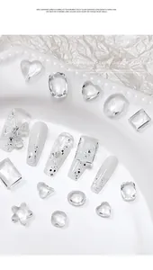 Close-up detail of various clear glass nail crystals and heart-shaped gems for manicure