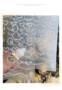 Gedetailleerde macro-opname van 3D-reliëf parel- en hartpatroon nagelstickers voor nagelkunst