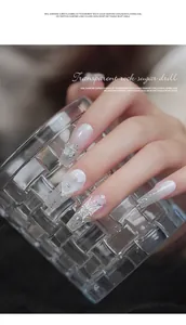 Detailed view of elegant white and silver glitter nail art with crystal butterfly charms.