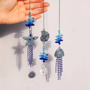 Squisiti ornamenti pendenti in cristallo blu a forma di stella marina, conchiglia e medusa.