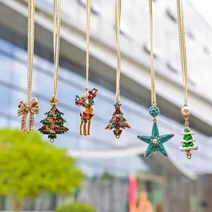 Détail de décorations de Noël colorées, comprenant un renne et des sapins en strass.
