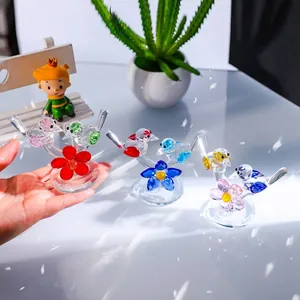 Handheld detail of miniature crystal bird and flower tabletop ornaments for home decor