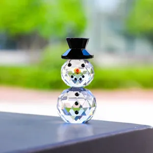 Detailed view of a faceted crystal snowman figurine with a black top hat for Christmas