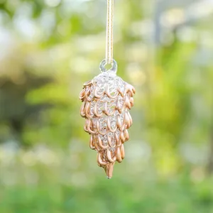 Detalle de un adorno de piña de cristal con lazos de oro rosa para decorar jardín