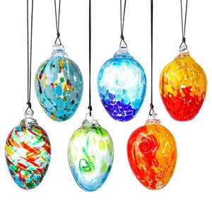 Detalle de seis coloridos adornos de vidrio soplado a mano en forma de huevos de Pascua