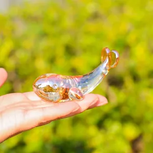 Primer plano de una figura de ballena de cristal transparente con tonos ámbar para escritorio
