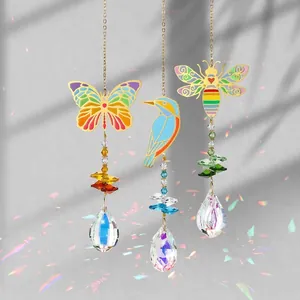 Détail d'attrape-soleil en cristal avec motifs en métal de papillon, oiseau et abeille