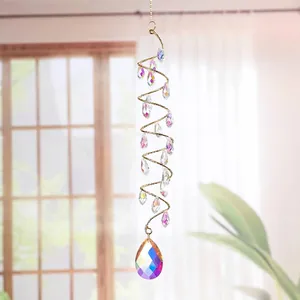 Atrapasol de cristal en espiral con cuentas irisadas colgado frente a una ventana.