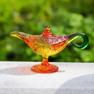 Ornamento de lámpara de Aladino de cristal colorido en repisa de piedra con jardín