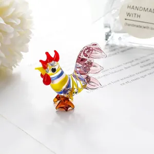 Macro view of a colorful handmade miniature glass rooster figurine with a gold crown.