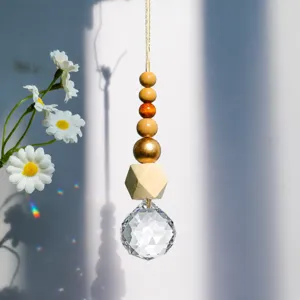 Close-up of crystal prism suncatcher with decorative wooden beads and rainbow light