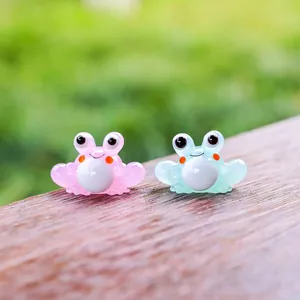 Primer plano de lindas figuritas de ranas de cristal en rosa y azul para decoración