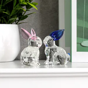 Nahaufnahme von exquisiten Kristallglas-Hasenfiguren mit rosa und blauen Ohren