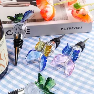 Detail showing faceted crystal butterfly wine bottle stoppers on a checkered cloth