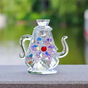 Primer plano de una tetera decorativa de cristal con incrustaciones de flores de colores