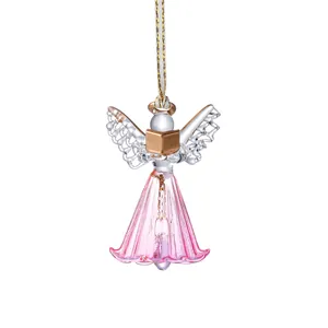 Atrapasol de ángel de cristal con falda plisada rosa y libro dorado decorativo.