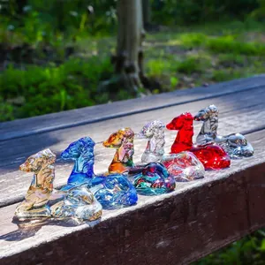 Colorful crystal deer animal figurines reflecting sunlight on a wooden bench