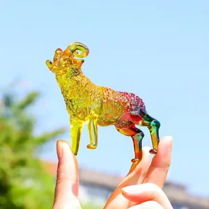 Macro dettagliata di una statuina di capra in cristallo colorato sfumato su sfondo cielo
