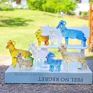 Set di sette figurine di capra in cristallo colorato su oggetti decorativi bianchi