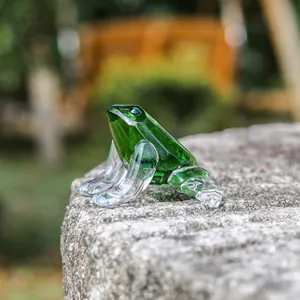 Detailed macro view of a green faceted crystal frog figurine on a stone surface