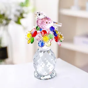 Détail macro d'une figurine d'oiseau en cristal sur des fleurs dans un vase facetté