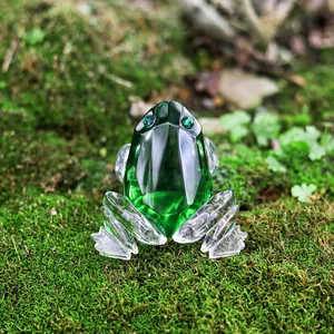 Detailed view of a faceted green crystal frog figurine placed on natural moss.