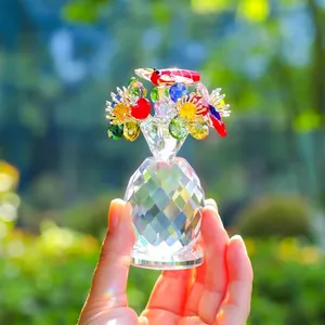 Vue rapprochée d'un vase en cristal fait main avec fleurs colorées et libellule rouge